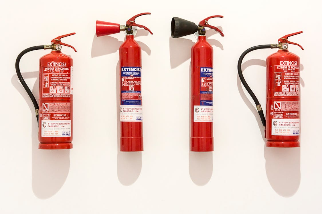A lineup of different fire extinguishers on a wall for fire safety in Chicago 